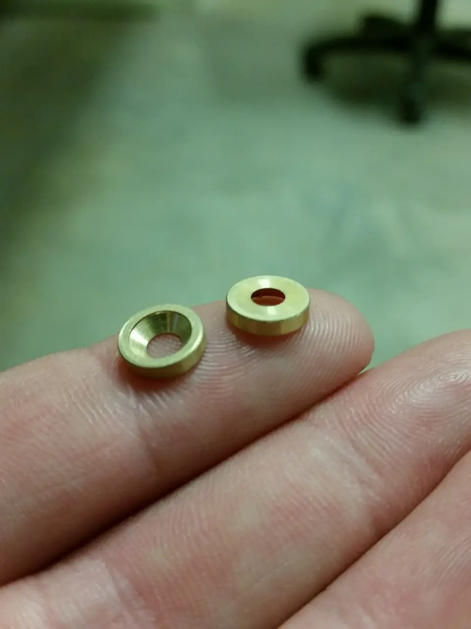 Small brass machined parts in hand