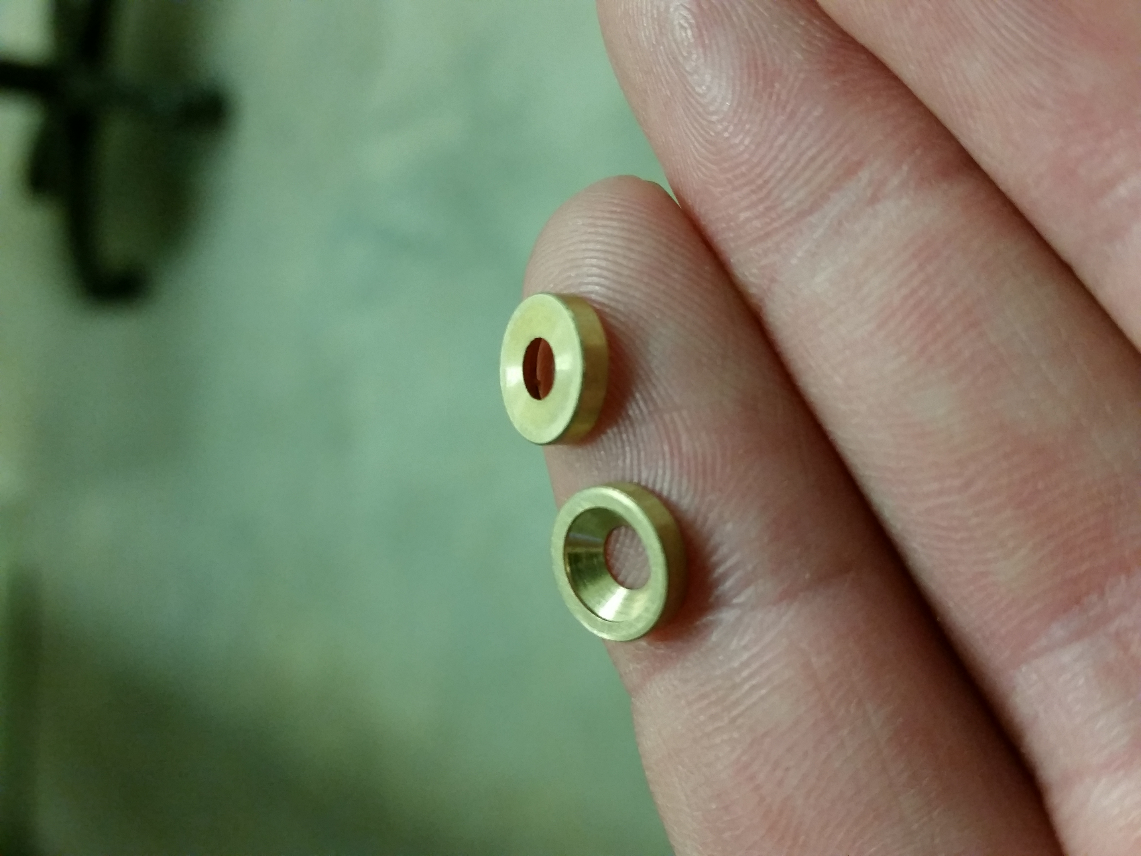 Small brass machined parts in hand